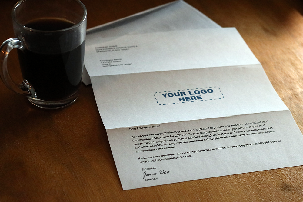 A sheet of paper on a desk showing a message from an employer on the back of a total compensation statement. 