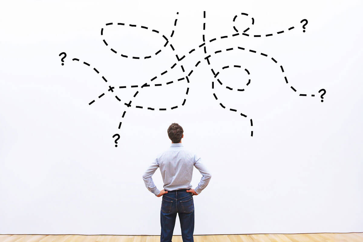 A man looking at a confusing map on a wall.