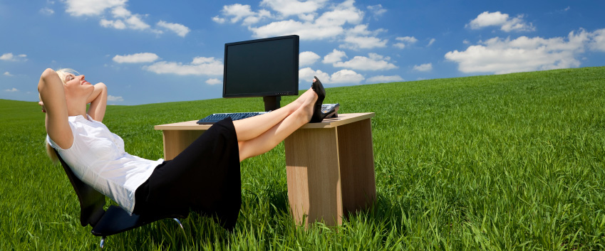 sitting at a computer desk in a field of grass while daydreaming of retirement on a nice summers day.